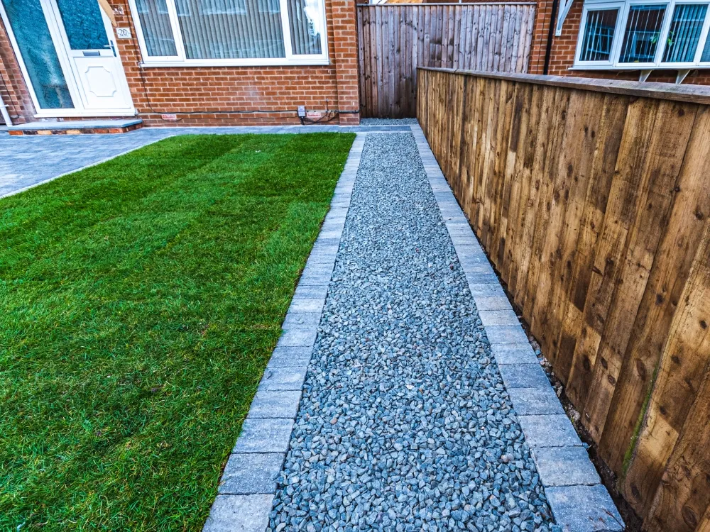 A paver-edged gravel side path running beside a lawn and a timber paling boundary fence - Fencing and Landscaping Experts, fencing and landscaping contractors in the Lower North Shore